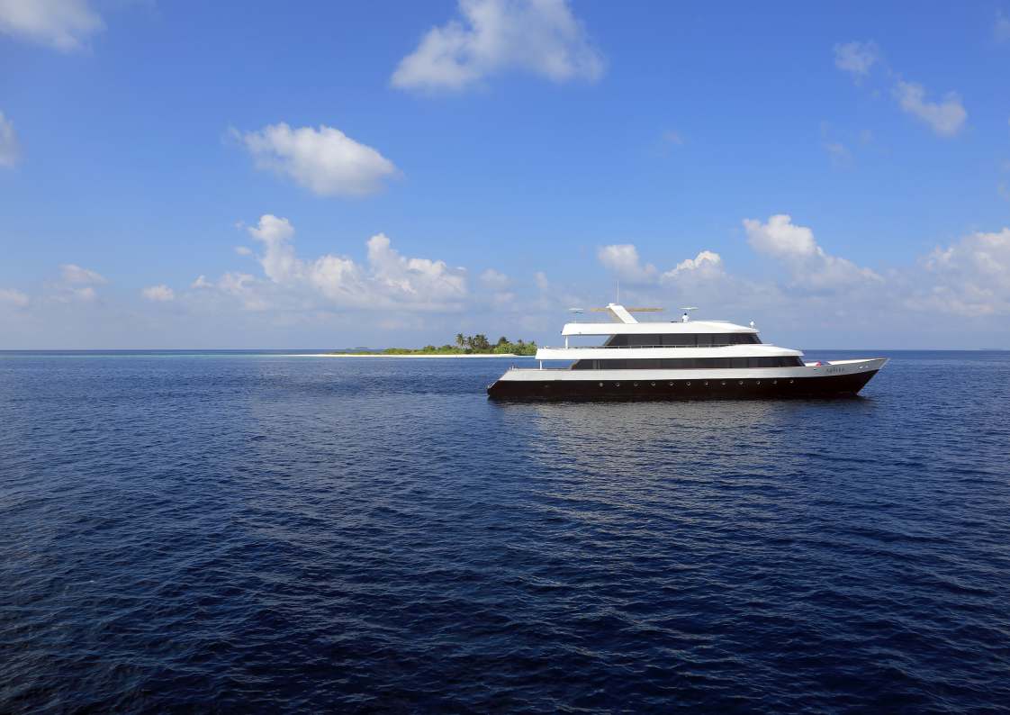 The yacht Azalea at anchor beside a small tropical island